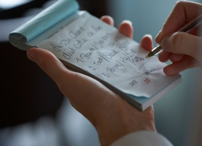 Waiter writing an order on a paper notepad